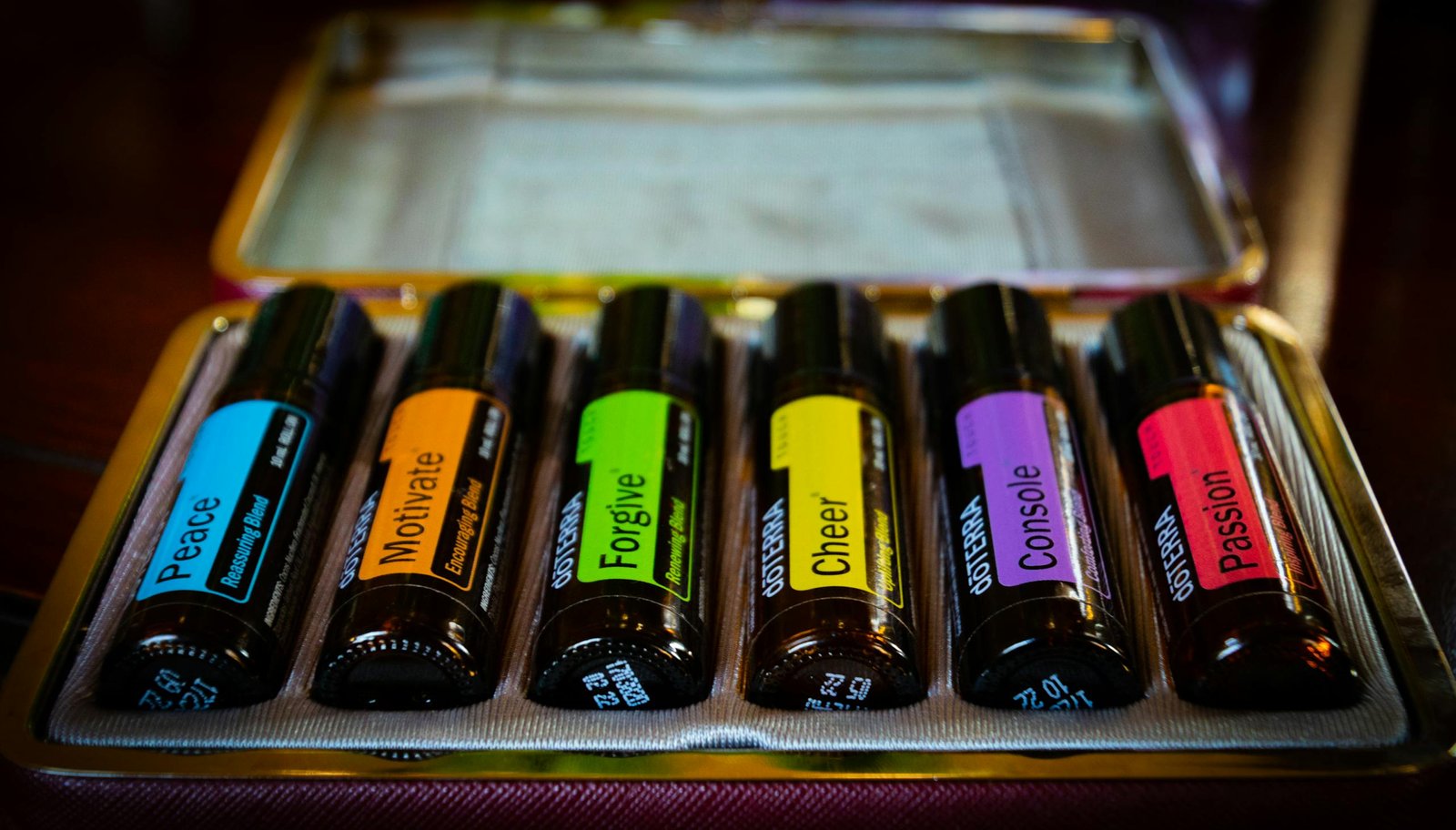Colorful essential oil bottles in a case, each labeled with emotional themes. Perfect for aromatherapy enthusiasts.